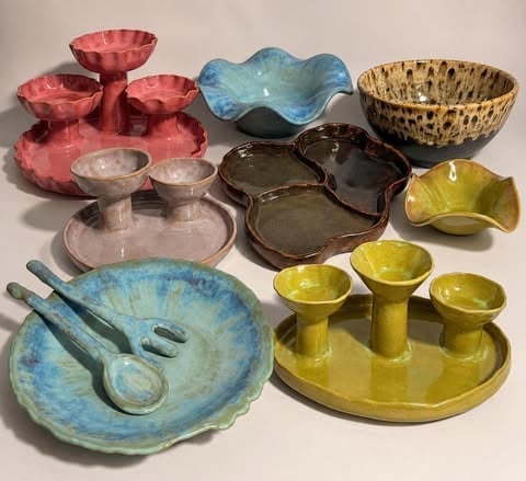 Kolekcja kolorowych ceramicznych naczyń i półmisków w odcieniach czerwieni, błękitu, żółci i brązu